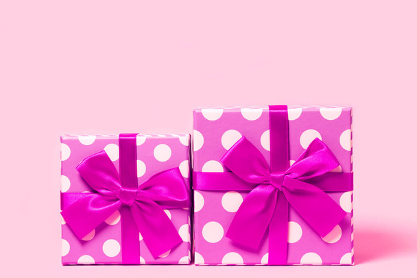 Δύο κουτιά δώρο με τελείες τυλιγμένο με φωτεινή κορδέλα στο χρώμα - Φωτογραφία, εικόνα