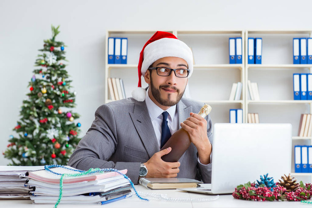 Νεαρός επιχειρηματίας γιορτάζει τα Χριστούγεννα στο γραφείο - Φωτογραφία, εικόνα