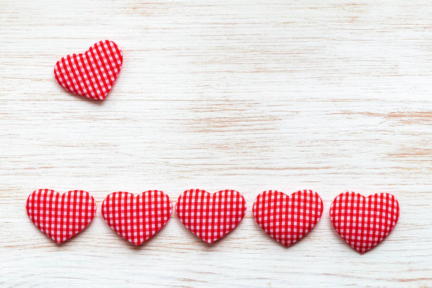 San Valentino sfondo con la linea di cuori tessili rossi e un cuore sopra su tavola di legno. Concetto di San Valentino
. - Foto, immagini