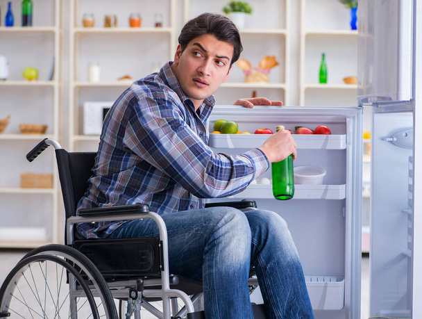 Jeune homme handicapé blessé ouvrant la porte du réfrigérateur - Photo, image