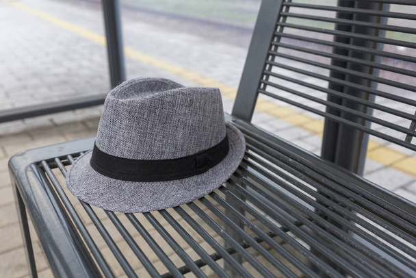 сірий капелюх на металевій лавці на зупинці поїзда
 - Фото, зображення