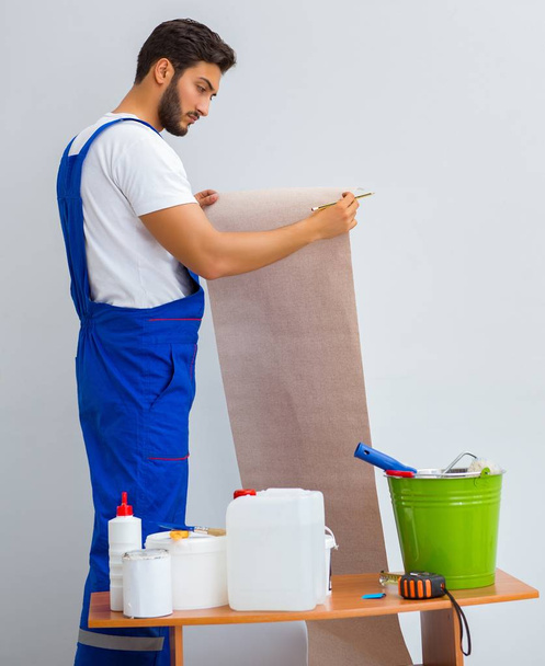 Worker working on wallpaper during refurbishment - Valokuva, kuva