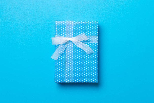Top view Christmas present box with white bow on blue background with copy space - Photo, Image