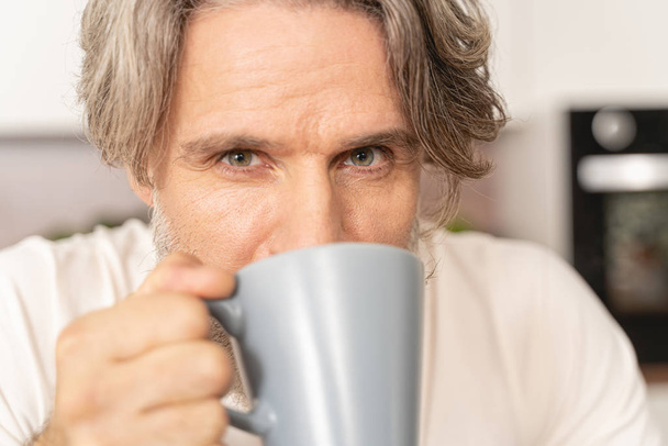 Mature adult with a cup looking forward - Foto, Imagen