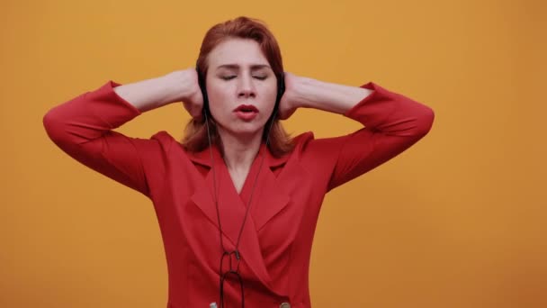 Scared woman having nice headphones, keeping hand on it, listening music - Footage, Video