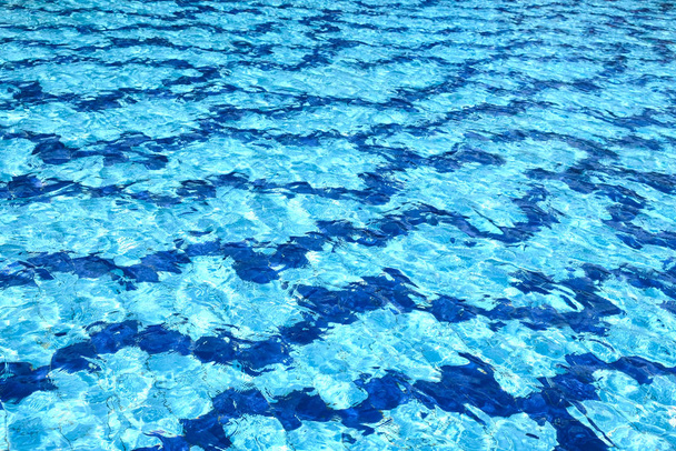 La superficie del agua de la piscina de color turquesa, iluminada por el sol
 - Foto, Imagen