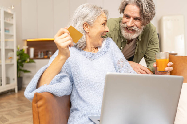 High-spirited middle-aged woman holding a credit card - Fotoğraf, Görsel