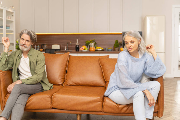 Two unhappy middle-aged Caucasian people sitting apart - 写真・画像