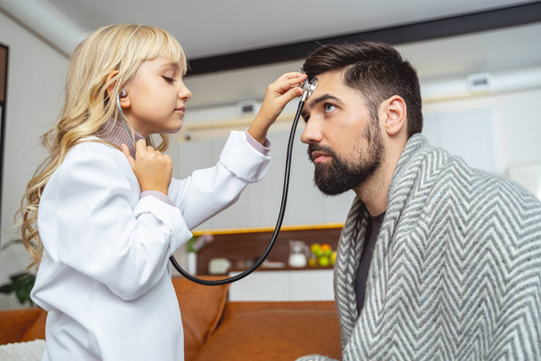 Little girl pretending to be doctor while playing with dad - Zdjęcie, obraz