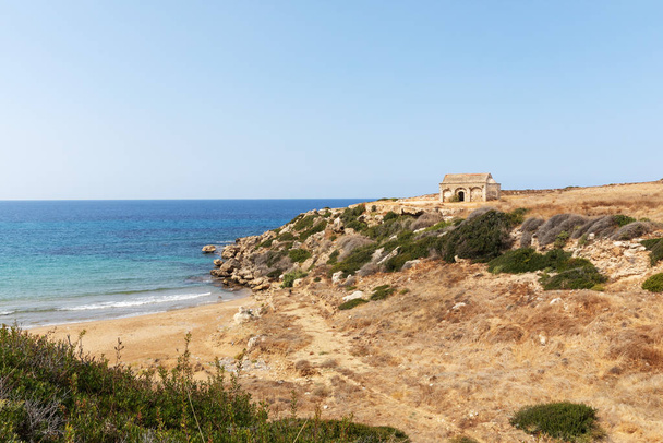 Mar Mediterráneo en el norte de Chipre. Las ruinas de un antiguo edificio en la isla. Verano a orillas del mar con agua azul transparente. Paisaje marino. Línea del horizonte
. - Foto, Imagen