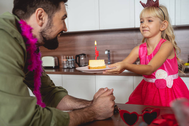 Cute little girl giving cake to father - Zdjęcie, obraz