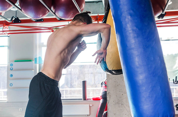 без сорочки м'язистий спортсмен ударяє сумку під час боксерської практики в бойовому клубі
 - Фото, зображення