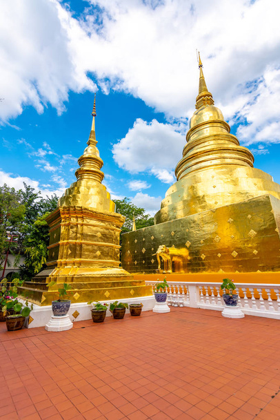 Beautiful view of Wat Phra Singh temple with golden chedi stupa and pagoda in Chiang Mai city, Thailand. Symbol of buddhism and ancient spirituality. Famous tourist destination. Summer weather - Photo, Image