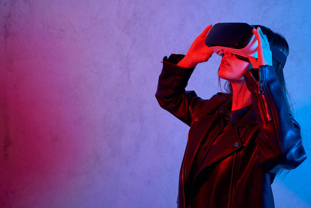 Chica joven que usa casco de realidad virtual mientras usa una chaqueta
 - Foto, Imagen