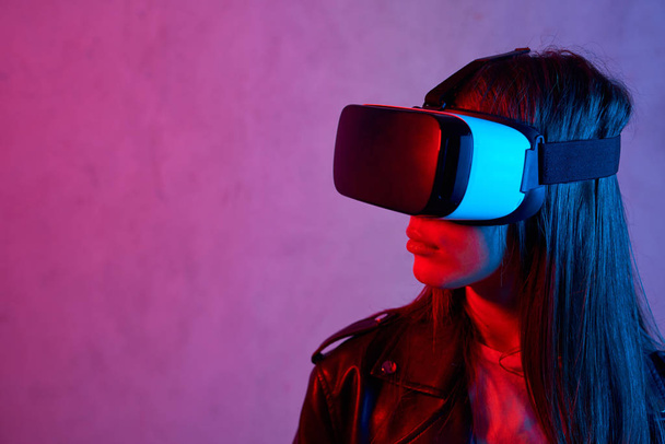 Giovane ragazza che utilizza il casco di realtà virtuale mentre indossa una giacca
 - Foto, immagini