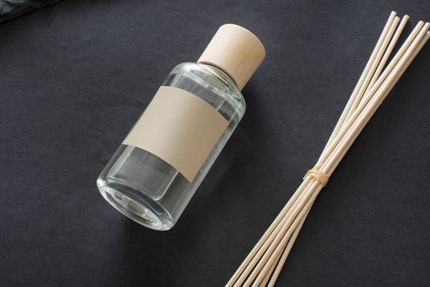 Diffuser indoor aroma sticks with glass bottle on black background - Zdjęcie, obraz