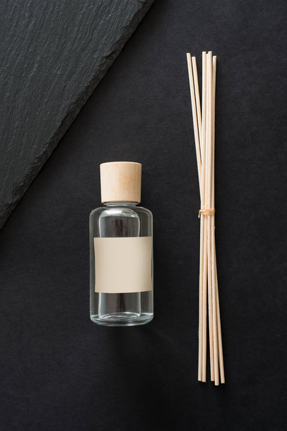 Diffuser indoor aroma sticks with glass bottle on black background - 写真・画像