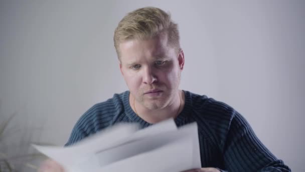 Close-up of dissatisfied Caucasian man looking through documents and throwing them away. Annoyed businessman having problems. Stress, depression, hardworking. - Metraje, vídeo