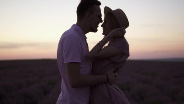 La silueta de cerca de una joven pareja feliz se besa en el fondo de un cielo al atardecer
 - Metraje, vídeo