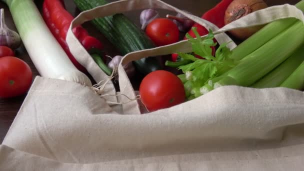 Eco bag with products vegetables.Zero waste use less plastic concept. Fresh vegetables organic in eco cotton fabric bags on wooden table - 映像、動画