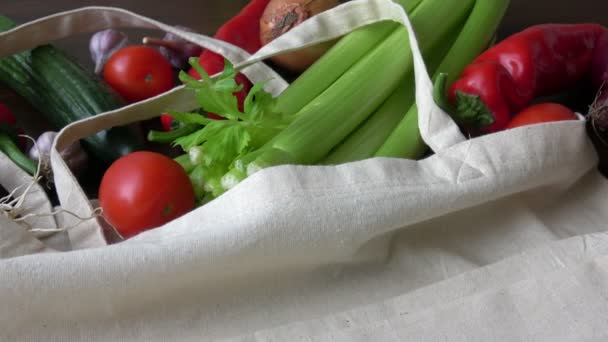 İçinde sebzeler olan bir poşet. Sıfır atık daha az plastik konsept kullanıyor. Taze sebzeler, ahşap masadaki pamuk kumaş torbalarında organik. - Video, Çekim