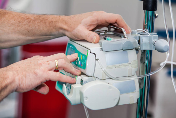 Анестезиолог в операционной, устанавливает аппарат для анестезии
 - Фото, изображение