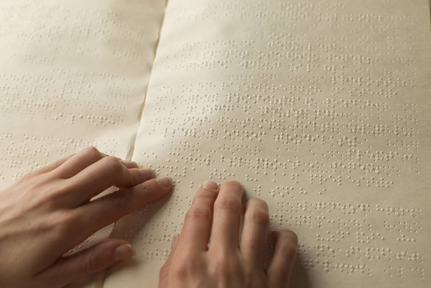 Ręka niewidomego czyta tekst książki Braille 'a. - Zdjęcie, obraz