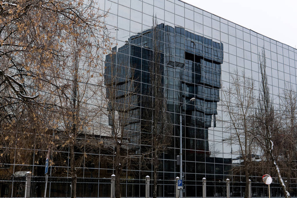 düsteres Winterstadtbild - Gebäude mit Glasfassaden sind spiegelglatt - Foto, Bild