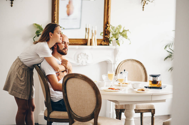 Young happy couple having breakfast at home together  - Photo, image