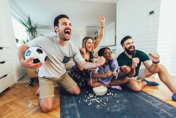 Группа веселых друзей смотрит футбольный матч и празднует
  - Фото, изображение