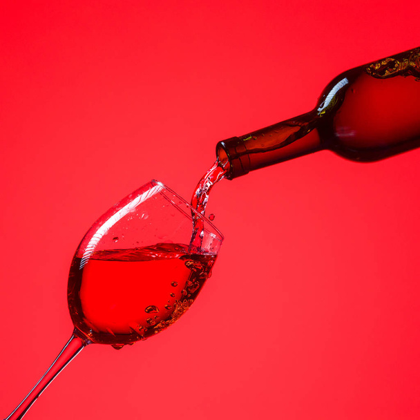Red wine is poured into a glass. - Φωτογραφία, εικόνα