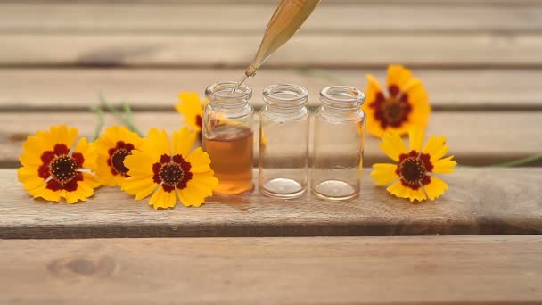 aceite esencial de coreopsis en una hermosa botella en la mesa
 - Imágenes, Vídeo