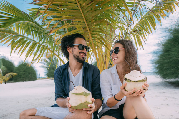 Pareja feliz de amantes con cócteles en una playa tropical
. - Foto, Imagen