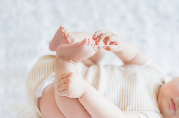 Close up of holding legs. Newborn 4 month skills concept. - Fotoğraf, Görsel