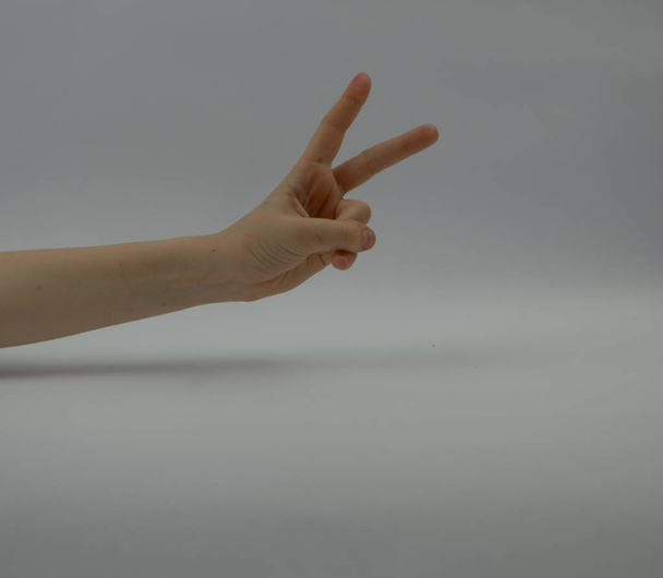 людська рука з двома пальцями, витягнутими перед столом
 - Фото, зображення