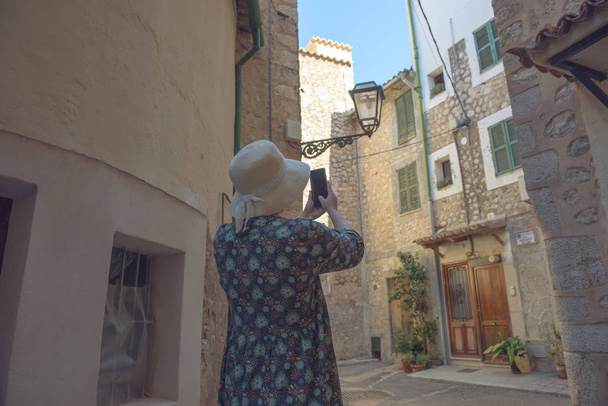 Крупним планом жінка, що йде в старому красивому селі на камені
 - Фото, зображення