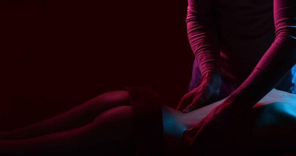 Back massage, spa center. Sexy massage, man hands. Sexy couple with slim body, beautiful spa salon. Intimate atmosphere. - Photo, Image