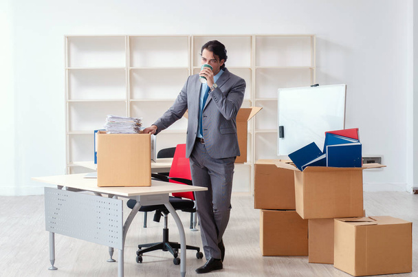 Молодой человек с коробками в офисе
 - Фото, изображение