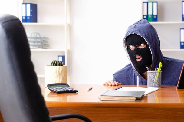 Hombre ladrón en pasamontañas en la oficina - Foto, imagen