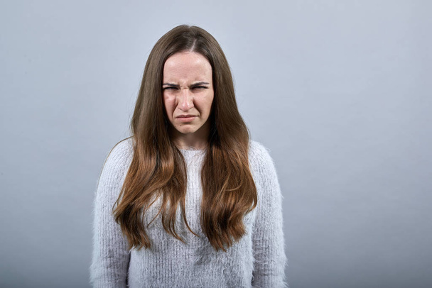 Розчарована леді плаче, стискаючи обличчя в модному синьому светрі
 - Фото, зображення
