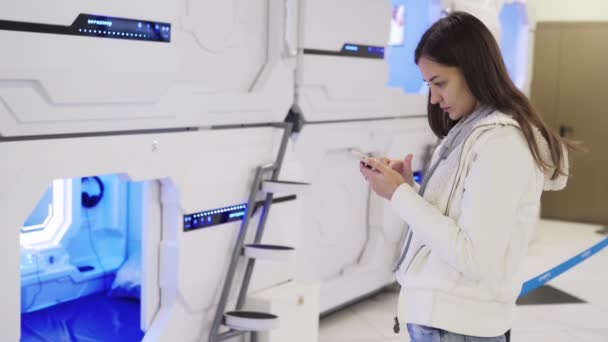 Mujer joven utiliza el teléfono para pagar en línea por cápsulas para dormir en el aeropuerto
 - Metraje, vídeo