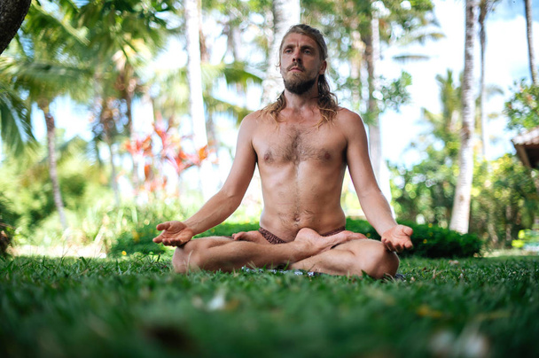 Erkek, dışarıda yoga ve meditasyon pratiği yapıyor. - Fotoğraf, Görsel