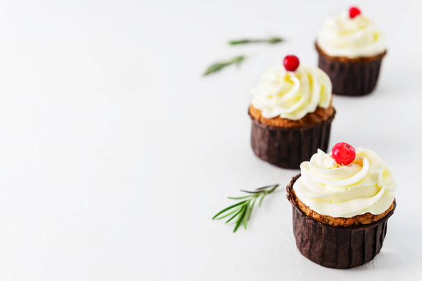 Carrot cupcakes with cream and cranberries on a white table. Horizontal orientation, copy space. - Φωτογραφία, εικόνα