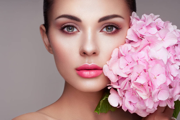 Portrait of beautiful young woman with flowers - Fotoğraf, Görsel