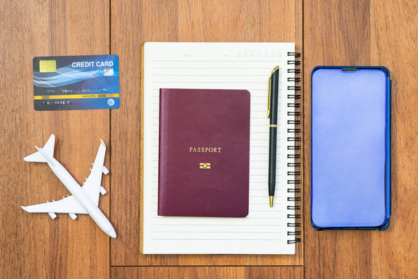 Airplane by passport and cellphone with notepad - Valokuva, kuva