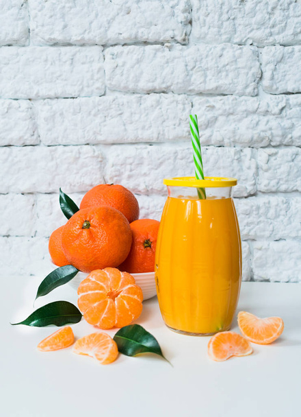 Tangerine juice on a white brick wall background. - 写真・画像