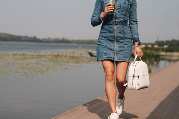 Portrait of One Beautiful Brunette Girl Dressed in Jeans Denim Overalls Spends Leisure Time - Fotó, kép