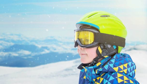 Retrato de un niño pequeño en traje de esquiador, halmet y gafas en la estación de esquí pico de montaña. Copiar espacio al lado
 - Foto, imagen