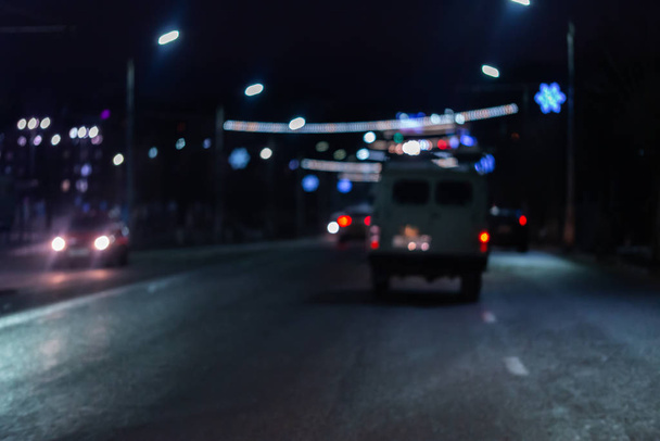 Gece sokak araba trafiğinin odağından çıkarılmış fotoğrafı. Renkli gece hayatı geçmişi. - Fotoğraf, Görsel