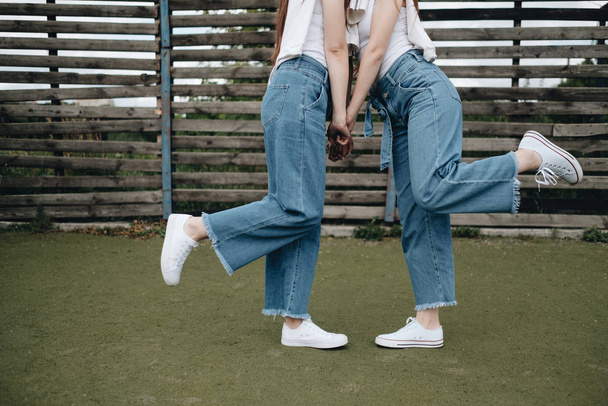 Portrait de deux jeunes sœurs jumelles brunes vêtues de jeans et de t-shirt blanc, Best Friends Forever Concept
 - Photo, image